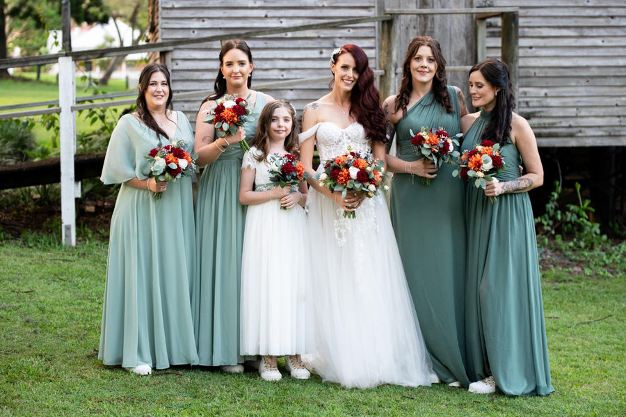 Bride and Bridesmaids holding artificial wedding flower bouquets in red, orange and white. Flowers by Flowers For Ever After