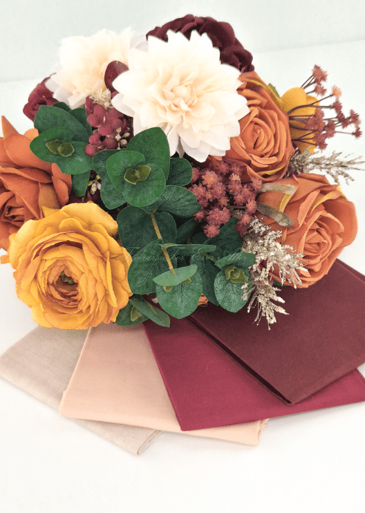 Artificial wedding bouquet colour pairing with rust and golden faux roses, cream dahlias, eucalyptus and cream, blush and burgundy fabric swatches. Made in Melbourne by Flowers For Ever After, shipping Australia and Worldwide.