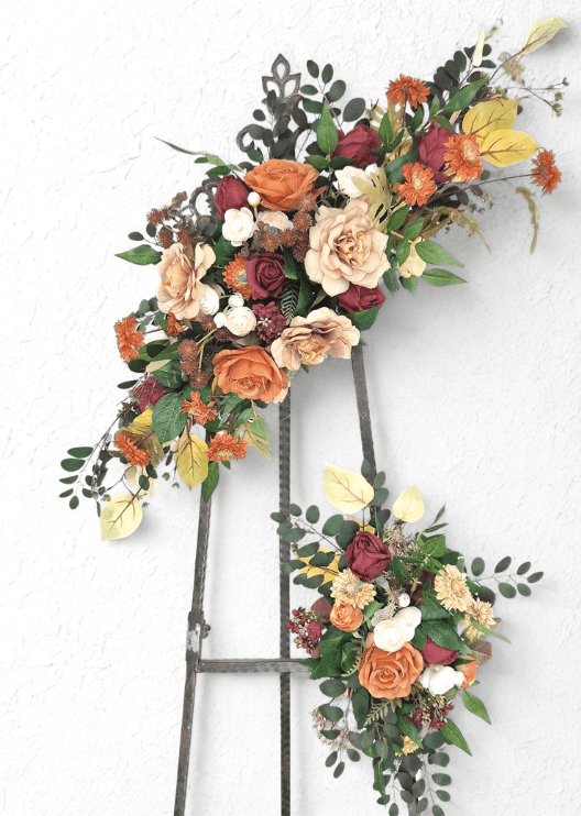Artificial wedding angled arbor floral set with rust, burgundy and beige faux roses, orange daisies, white ranunculus and eucalyptus. Made in Melbourne by Flowers For Ever After, shipping Australia and Worldwide.