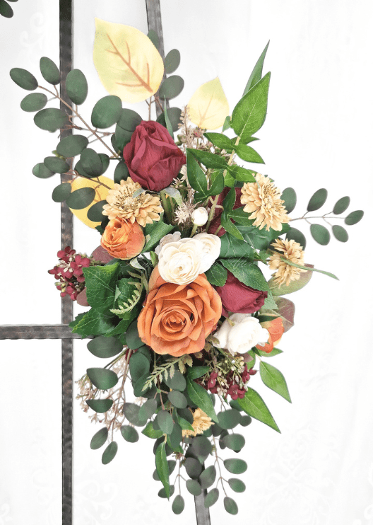 Artificial wedding smaller arbor spray with rust and burgundy faux roses, golden daisies, white ranunculus and eucalyptus. Made in Melbourne by Flowers For Ever After, shipping Australia and Worldwide.