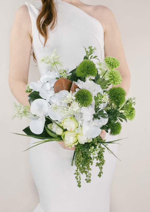 Artificial wedding bridal bouquet with white faux orchids, green pompom blooms, lime green flowers and trailing green buds. Made in Melbourne by Flowers For Ever After, shipping Australia and Worldwide.