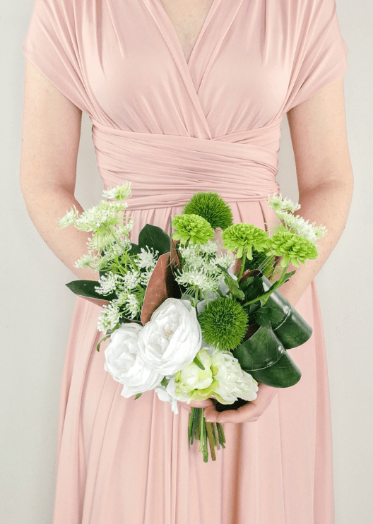 Artificial wedding bouquet held in both hands, with white faux roses, green pompom flowers, lime green blooms and curled dark leaves. Made in Melbourne by Flowers For Ever After, shipping Australia and Worldwide.