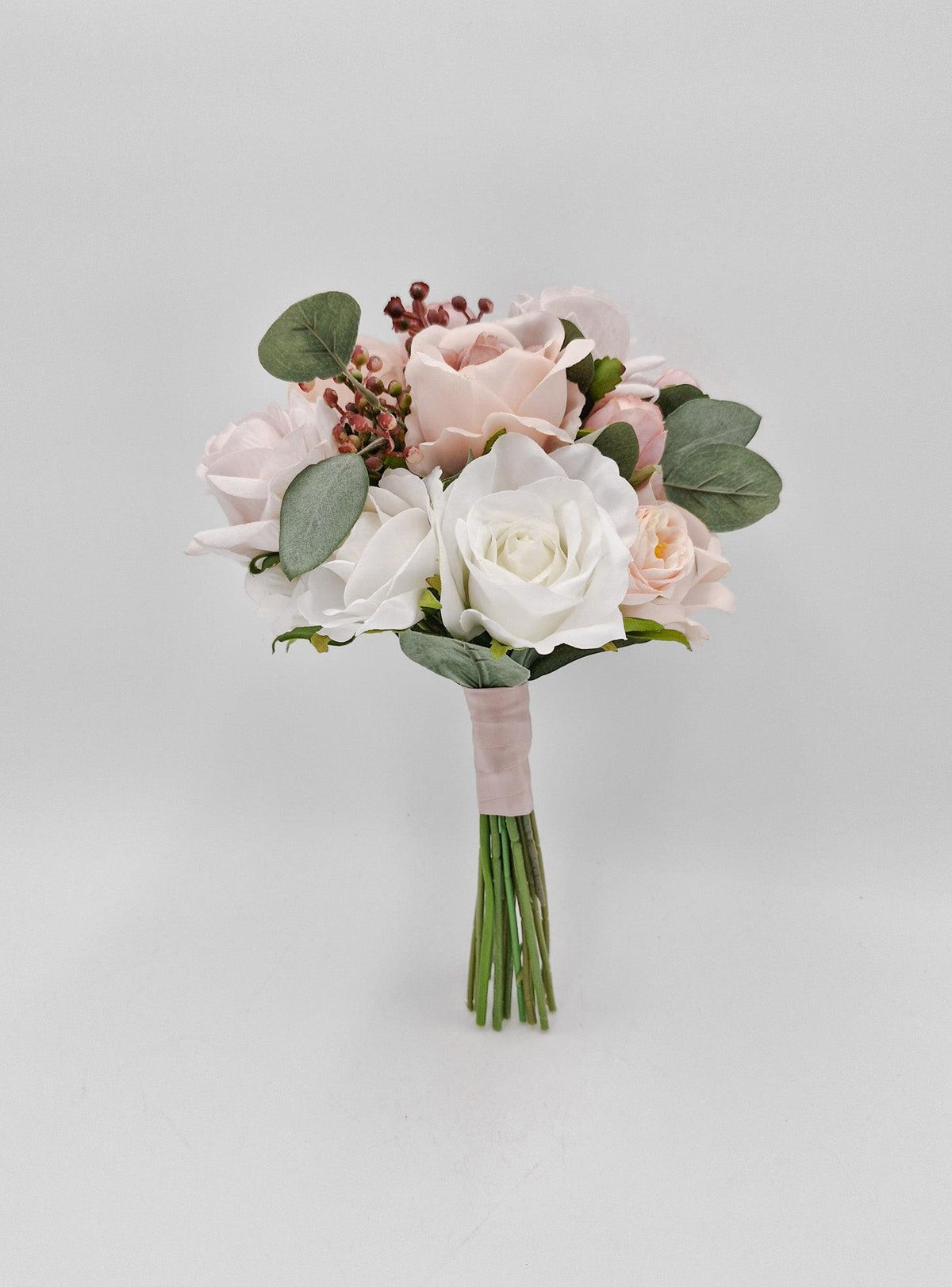 Artificial wedding flower girl posy with blush and white faux roses, eucalyptus and berry sprigs, with a blush-wrapped handle. Made in Melbourne by Flowers For Ever After, shipping Australia and Worldwide.