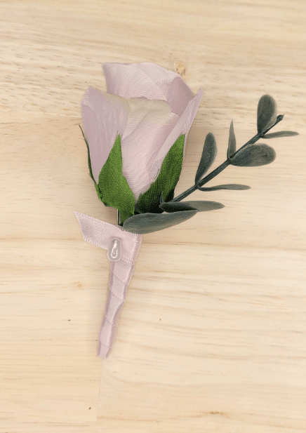 Artificial wedding boutonniere with pale lavender faux rosebud, grey-green foliage and lavender-wrapped stem. For formals, proms and ball occasions. Made in Melbourne by Flowers For Ever After, shipping Australia and Worldwide.