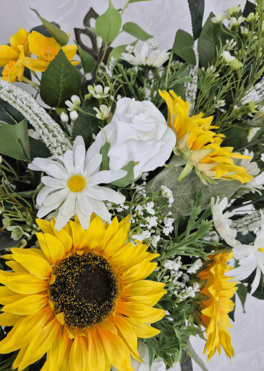 Artificial wedding arbor flowers, angled view of yellow faux sunflowers, white blooms and cascading greenery. Made in Melbourne by Flowers For Ever After, shipping Australia and Worldwide.