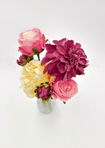 Artificial wedding table arrangement, overhead view of pink faux roses, a burgundy dahlia and cream blooms in a glass bottle. Made in Melbourne by Flowers For Ever After, shipping Australia and Worldwide.