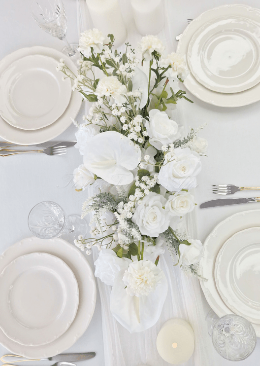 Artificial wedding table arrangement, angled view of white faux roses, orchids, hydrangea and green leaves. Made in Melbourne by Flowers For Ever After, shipping Australia and Worldwide.