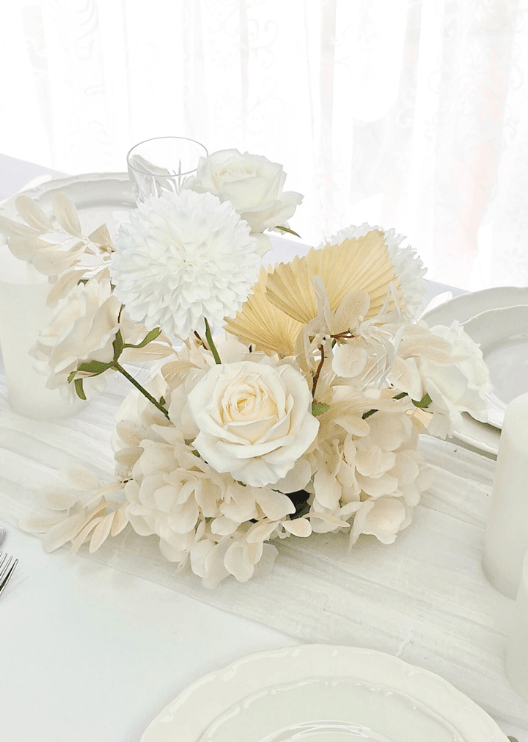 Artificial wedding table centrepiece close-up with white faux flowers and green foliage. Made in Melbourne by Flowers For Ever After, shipping Australia and Worldwide.