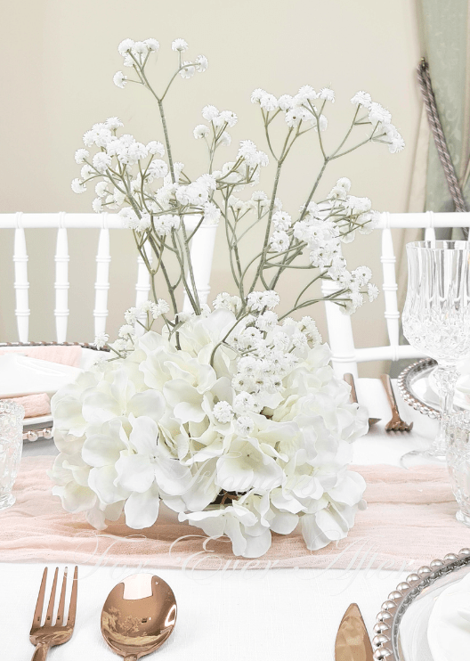 Artificial wedding table centrepiece with a rounded base of white faux hydrangea blooms and tall branching baby's breath. Made in Melbourne by Flowers For Ever After, shipping Australia and Worldwide.
