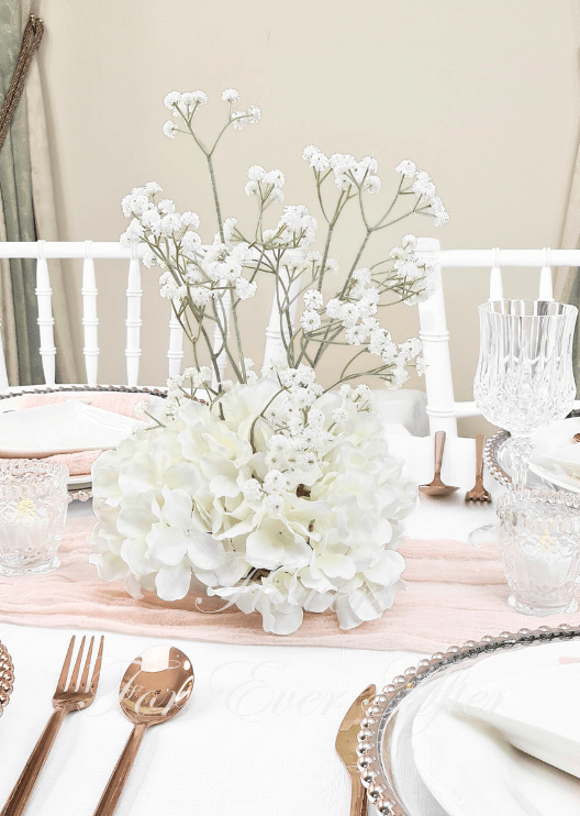 Artificial wedding table centrepiece, front view of white faux hydrangea clusters and tall delicate baby's breath sprigs. Made in Melbourne by Flowers For Ever After, shipping Australia and Worldwide.