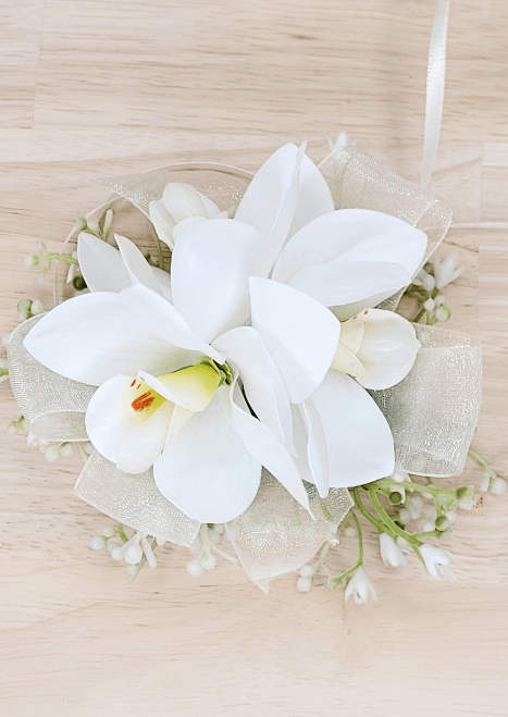 Artificial wedding wrist corsage with white faux orchids, tiny pale buds and ivory organza ribbon loops. For formals, proms and ball occasions. Made in Melbourne by Flowers For Ever After, shipping Australia and Worldwide.