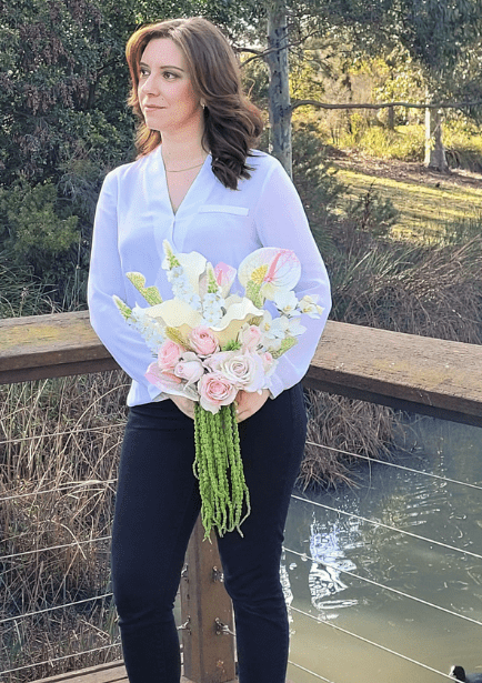Artificial wedding bouquet held by a person, with pink and white faux blooms, white anthuriums and long green trailing strands. Made in Melbourne by Flowers For Ever After, shipping Australia and Worldwide.