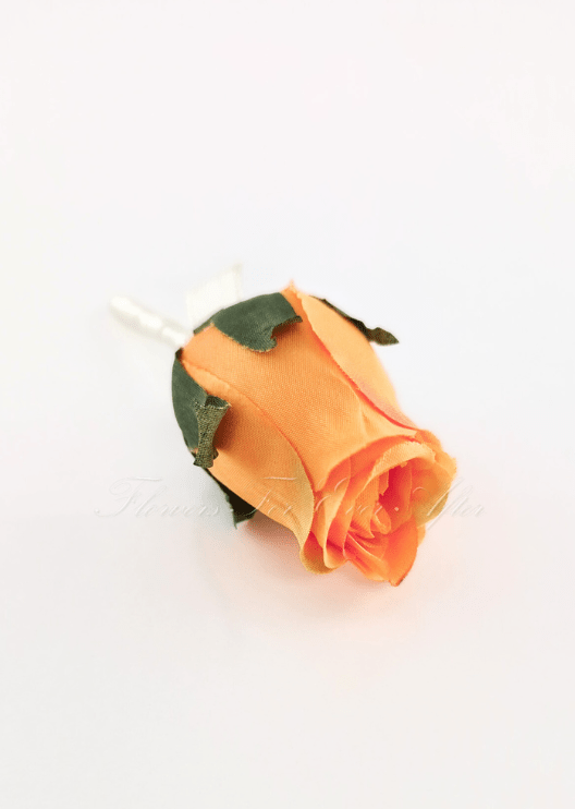 Artificial wedding boutonniere close-up showing an orange faux rosebud and green sepals. For formals, proms and ball occasions. Made in Melbourne by Flowers For Ever After, shipping Australia and Worldwide.