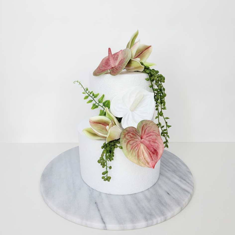 Artificial wedding cake decoration with pink and green faux anthuriums, white orchids and trailing greenery arranged over two tiers. For birthday, event and celebration cakes. Made in Melbourne by Flowers For Ever After, shipping Australia and Worldwide.