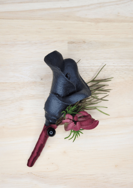 Artificial wedding boutonniere with black faux calla lilies, burgundy blossoms, fine green sprigs and burgundy-wrapped stem. For formals, proms and ball occasions. Made in Melbourne by Flowers For Ever After, shipping Australia and Worldwide.