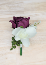 Artificial wedding boutonniere with plum faux rosebud, white orchid, green berries and white-wrapped stem. For formals, proms and ball occasions. Made in Melbourne by Flowers For Ever After, shipping Australia and Worldwide.