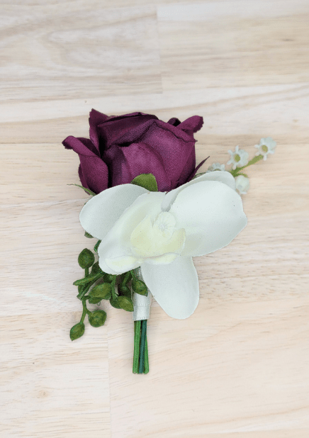 Artificial wedding boutonniere with plum faux rosebud, white orchid, green berries and white-wrapped stem. For formals, proms and ball occasions. Made in Melbourne by Flowers For Ever After, shipping Australia and Worldwide.