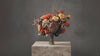 A rustic orange and purple autumn toned faux flower wedding bouquet. Flowers by Flowers For Ever After
